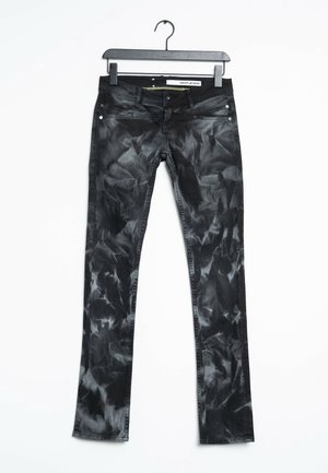 Schwarze Acid-Wash-Jeans mit fünf Taschen, aufgehängt an einem schwarzen Kleiderbügel vor weißem Hintergrund, mit der Aufschrift "DKNY JEANS."