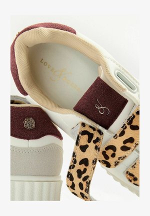 Zapatilla blanca con ante burdeos, acentos beige y una correa con estampado de leopardo. Logotipo dorado en la plantilla y un detalle de emblema floral.