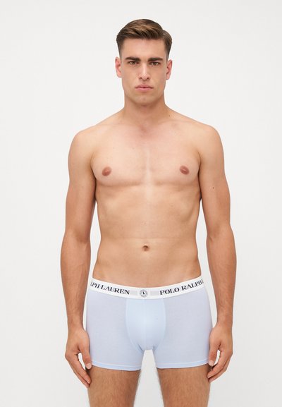 Fehér boxeralsó, testhez simuló fazonban, pamutból készült, kontrasztos derékrésszel, amelyen a "POLO RALPH LAUREN" logó található. Simaság jellemzi, minimális dizájnnal.
