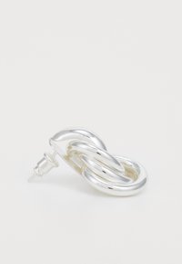 Boucle d'oreille en argent avec un design fluide et tordu, et une attache à tige. Surface lisse et réfléchissante avec des bords arrondis et des maillons.