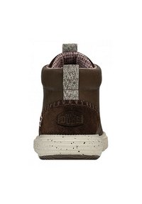 Stivale alla caviglia in suede marrone con collo in maglia testurizzata, suola bianca maculata e linguetta posteriore. Presenta il logo sul tallone.