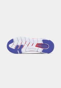 Reebok sportbačių padas, pagamintas iš baltos gumos su violetiniais akcentais, tekstūruota danga sukibimui ir įspaustu prekės ženklu.