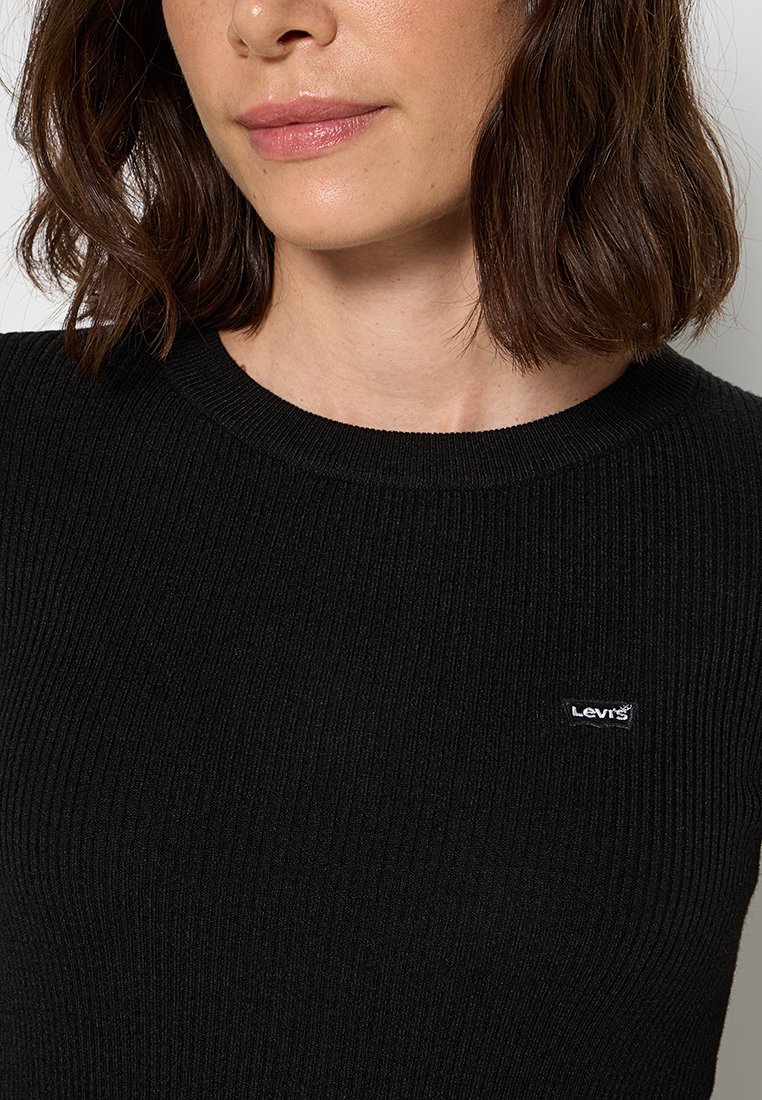 Maglione a costine nero con girocollo. Presenta una piccola etichetta con il logo bianco di Levi's sul davanti. Tessuto testurizzato con leggero elastico.