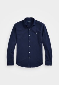 Marinblå skjorta med lång ärm och knappar, tillverkad av bomullsblandning. Den har en klassisk krage, vita knappar och en liten broderad logotyp på bröstet.