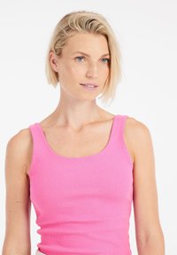 Aansluitend roze katoenen tanktop met brede banden en een ronde halslijn, voorzien van een geribbelde textuur en een gladde afwerking.