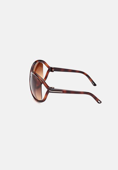 Schildpatt-Sonnenbrille mit großem, rundem Gestell und braunen Verlaufslinsen sowie schlanken Bügeln, die ein modernes Design und ein elegantes Finish betonen.