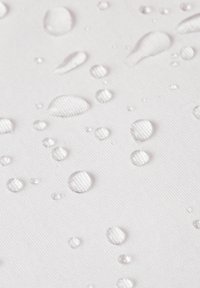 Druppels water op een gestructureerd witte ondergrond, met verschillende groottes en vormen. De ondergrond lijkt glad met duidelijke reflecties.