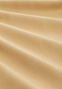 Beige Stoff mit einer glatten Textur, der subtile diagonale Falten und eine gleichmäßige Oberfläche zeigt. Es sind keine Muster oder Verzierungen sichtbar.