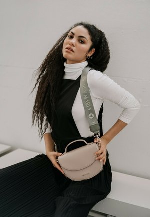 Crossbody tas van zacht beige leer met een gebogen vorm, voorzien van een bovenhandvat en een verstelbare groene schouderband met logo-opdruk.
