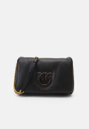 Borsa a spalla in pelle nera con tracolla a catena dorata e design di faccina sorridente con due foglie. Texture liscia e forma rettangolare.