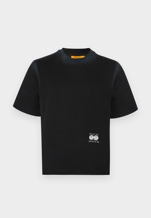 Fekete rövid ujjú, kerek nyakú póló kis fehér fogaskerék grafikával és a „Replay Inc.” felirattal a jobb alsó szegély közelében.