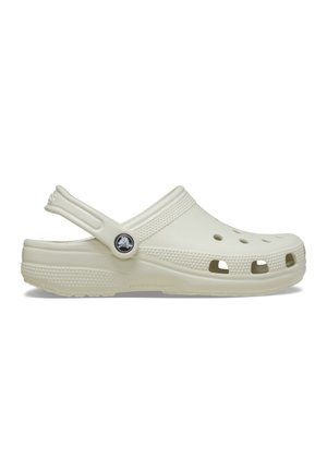 Sabot en caoutchouc blanc cassé avec des trous de ventilation, semelle texturée et bride de talon réglable avec un logo circulaire noir.