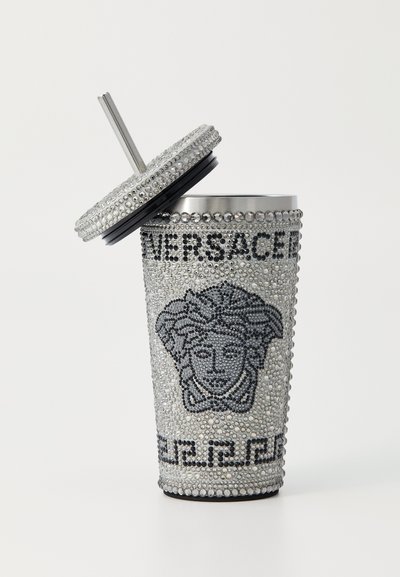 Silver studded cup with a lid, featuring a black Versace emblem and logo. Smooth texture with a patterned crystalline surface.