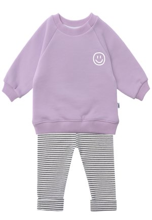 Lavender long-sleeve sweatshirt with white smiley face on chest paired with white and black striped pants with cuffs.