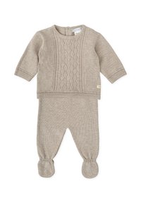 Ensemble deux-pièces beige en tricot avec des manches longues, un design en tricot torsadé texturé sur le haut et un pantalon avec pieds et des poignets côtelés.