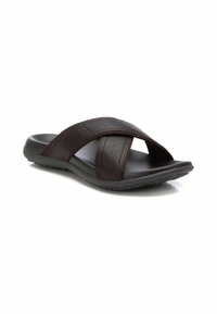 Sandalia deslizante de cuero marrón con tiras cruzadas, perforaciones sutiles, plantilla acolchada y una suela de goma gris texturizada.