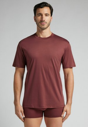 Bordeaux kortoren T-shirt en bijpassende shorts, gemaakt van glatte stof. Eenvoudig ontwerp met een ronde hals en minimale details.