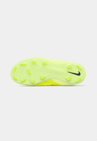 Culoarea galben-verde strălucitor a tălpii de ghete de fotbal, cu știfturi rotunde și unghiulare și un logo Nike negru pe un fundal alb simplu.