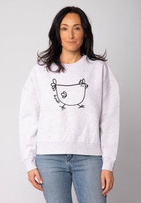 Lichtgrijze sweatshirt gemaakt van zacht materiaal, met een grote zwarte lijntekening van een kip op de voorkant. Losse pasvorm met ribbels aan de mouwen.