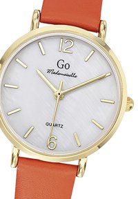 Montre en quartz tonnée or avec un cadran texturé blanc, un bracelet en cuir orange et des index dorés aux positions 12, 3, 6 et 9 heures.