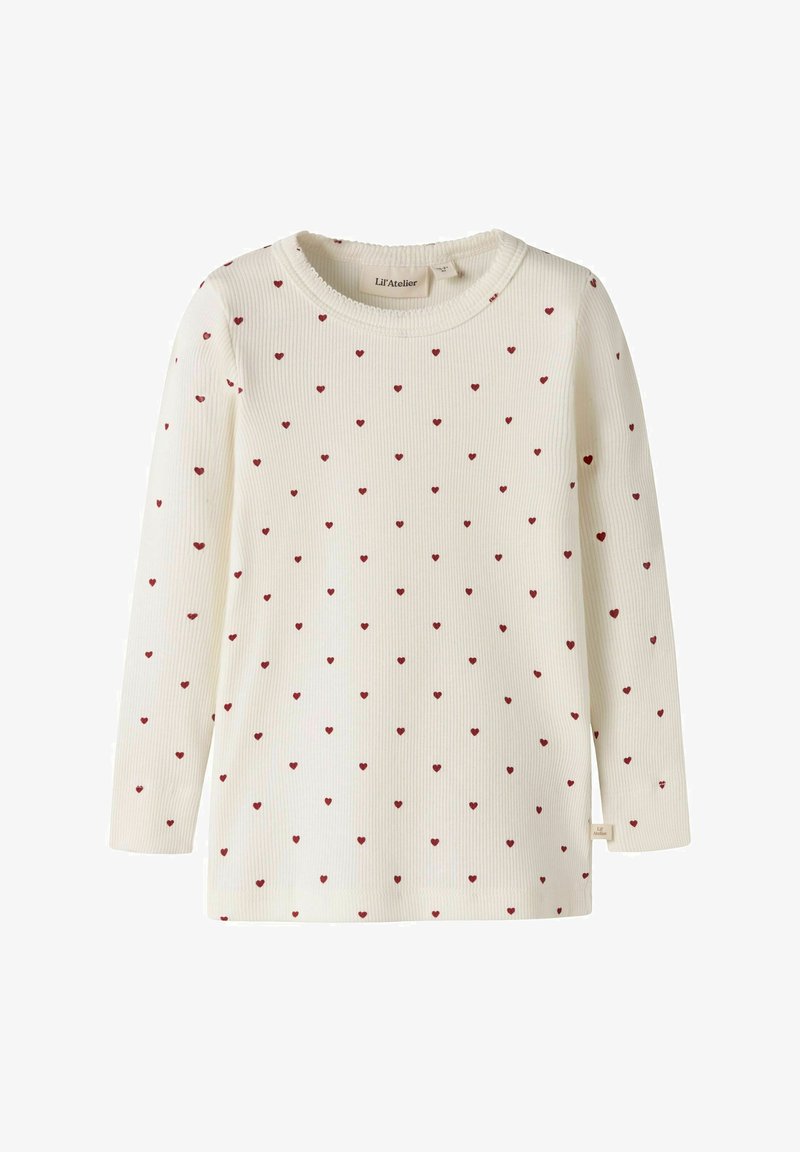 Chemise crème à manches longues côtelée avec de petits motifs de cœurs rouges répartis uniformément sur le tissu.