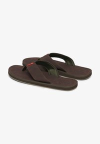 Chanclas marrones con suela verde oscuro. Plantilla texturizada, correas anchas, costuras sutiles y un pequeño acento rojo en una de las correas.