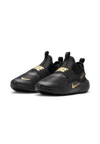 Zapatillas deportivas negras con una parte superior texturizada, que presentan un logo de Nike dorado y acentos. Diseñadas con una suela redondeada y correas elásticas.