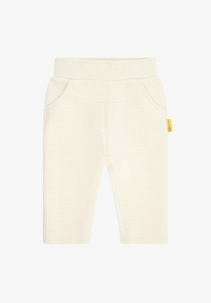 Crèmekleurige peuterpantalon van zachte stof, met een gladde textuur, elastische tailleband en twee zijzakken. Gele merketiket bevestigd.