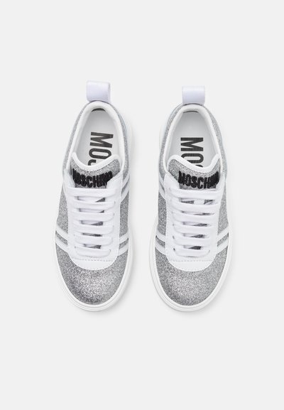 Zapatillas de deporte grises con purpurina y acentos blancos, con punta redonda, cordones planos y el nombre de la marca impreso en la lengüeta.