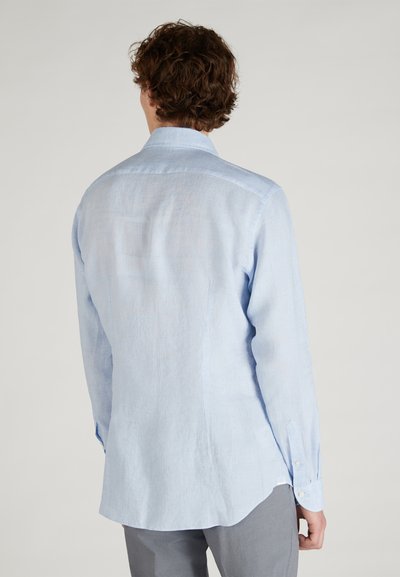 Camicia azzurro chiaro a maniche lunghe in lino, con colletto a punta, polsini con bottoni e orlo curvo. Texture liscia con una leggera lucentezza.
