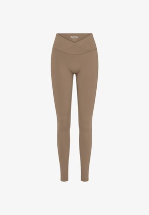 Barna leggings magas, keresztbe szerkesztett derékkal. Simává és rugalmassá tett anyagból készült. Testhezálló dizájn, amely a bokák felé szűkül. Nincsenek látható minták.