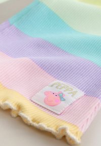 Dzianinowy koc bawełniany w pastelowych paskach zielonego, lawendowego, różowego i żółtego koloru z falbanką i naszywką Peppa Pig.