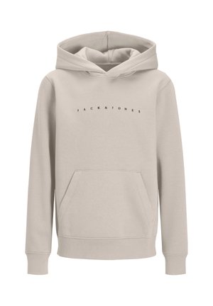Garçon portant un sweat à capuche beige Jack & Jones, un pantalon noir, des chaussures beiges et une casquette noire, debout devant un fond clair uni.