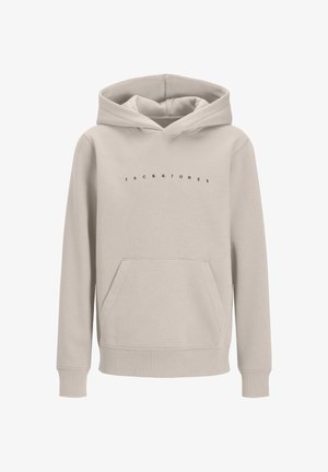 Garçon portant un sweat à capuche beige Jack & Jones, un pantalon noir, des chaussures beiges et une casquette noire, debout devant un fond clair uni.