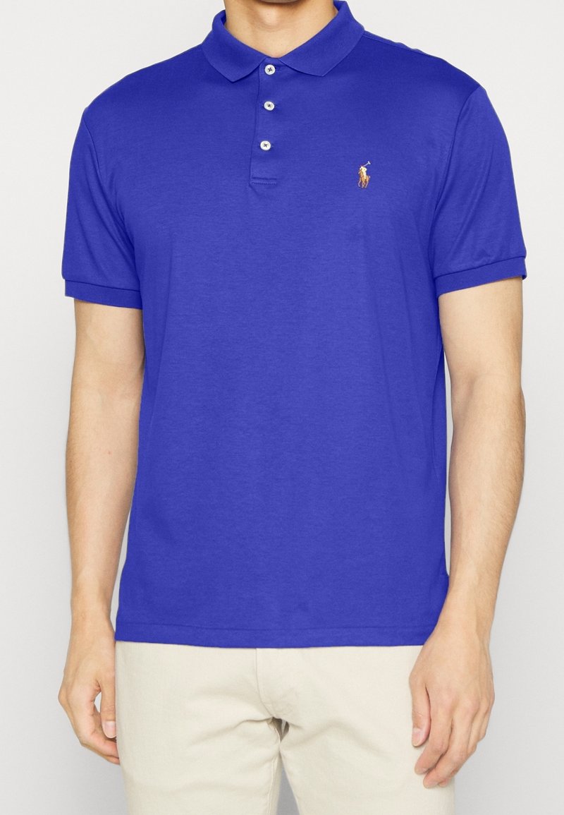 Polo shirt en coton bleu avec un col, une patte de boutonnage à trois boutons et un petit logo sur la poitrine gauche ; manches courtes avec des poignets retournés.