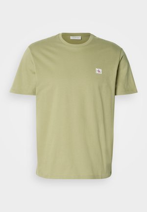 T-shirt verde oliva a maniche corte realizzato in cotone morbido. Presenta un piccolo logo rettangolare sulla parte sinistra del petto. Design classico con collo a girocollo.