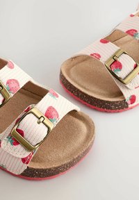 Erdbeer-musternde Sandalen mit cremefarbenen Riemen, zwei metallischen Schnallen und Korkfußbett. Strukturierte Gummisohle in Pink für besseren Halt.