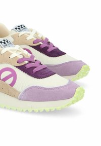 Sneaker viola e beige con tomaia in rete, dettagli in suede, lacci bianchi e suola verde testurizzata. Presenta il logo sul lato e una lingua a scacchi.