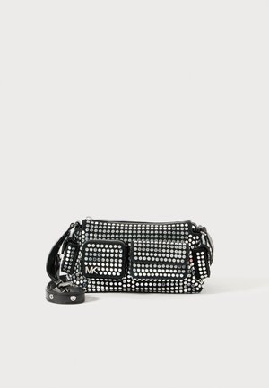 Schwarze Handtasche mit silbernen Nieten, zwei vorderen Taschen, einem abnehmbaren Trageriemen und "MK" Logo auf einer Tasche, abgebildet vor einfachem Hintergrund.