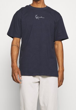 Navyblauwe katoenen t-shirt met een ronde halslijn, korte mouwen, een losse pasvorm en een wit geborduurd logo op de borst. Eenvoudig en minimalistisch ontwerp.