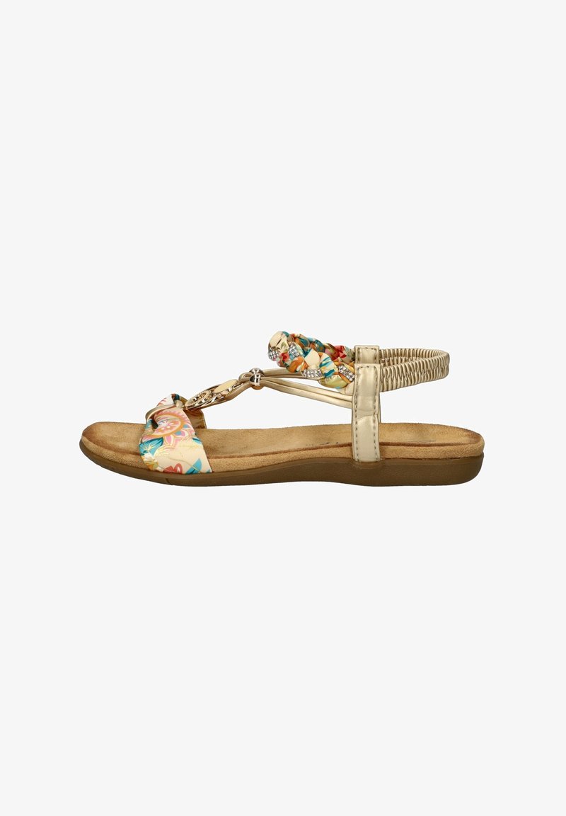 Flat sandal featuring a floral fabric upper in cream, with braided detailing and metallic accents. Cushioned beige sole for comfort.
