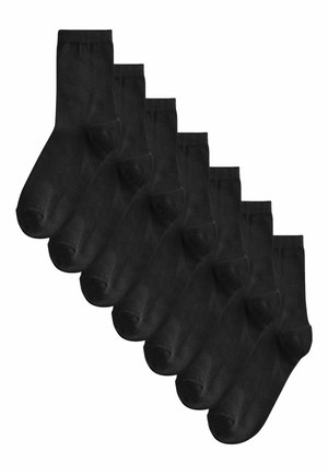 Kuus paari tavalisi musti pahkluu sokke, mis on paigutatud astmelises kattuvuses mustris valgel taustal.