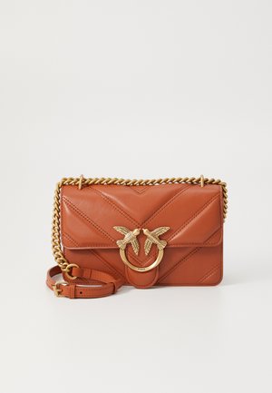 Bolso cruzado de cuero marrón con patrón en chevron, correa de cadena dorada y adornos decorativos de pájaros en un cierre circular.