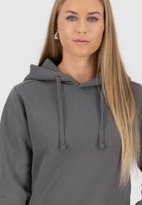 Grijze hoodie met een trekkoordcapuchon en een zachte textuur. Fitted stijl met lange mouwen, zonder zichtbare patronen of accenten.