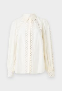 Weiße Bluse mit einem Knopfkragen, strukturiertem Stoff und filigranen Spitzenausschnitten an den Seiten und Ärmeln.