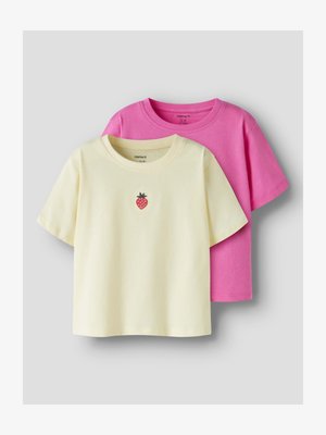 Δύο παιδικά T-shirts με κοντά μανίκια, ένα απαλό κίτρινο με μικρό γραφικό φράουλας και ένα μονόχρωμο φωτεινό ροζ, τοποθετημένα επίπεδα.