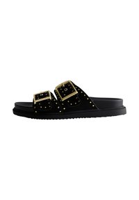 Sandales à glisser en suede noir avec deux boucles dorées surdimensionnées et des détails cloutés le long des lanières, avec une semelle en caoutchouc texturé.
