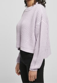 Maglione cropped di un leggero viola con un motivo a maglia testurizzato, polsini e orlo a costine, caratterizzato da spalle basse e maniche larghe.