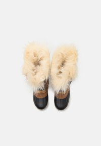 Svart fusk läderstövlar med ett fluffigt beige pälsfäste, accentuerade med bruna remmar. Rund tå och texturerad sula för bättre grepp.
