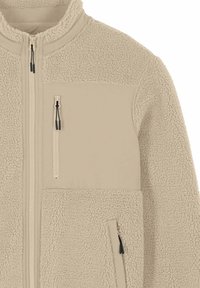 Giacca in pile beige con zip frontale integrale, tasca sul petto con zip e tasca laterale con zip, caratterizzata da pannelli di tessuto texturizzato e liscio.